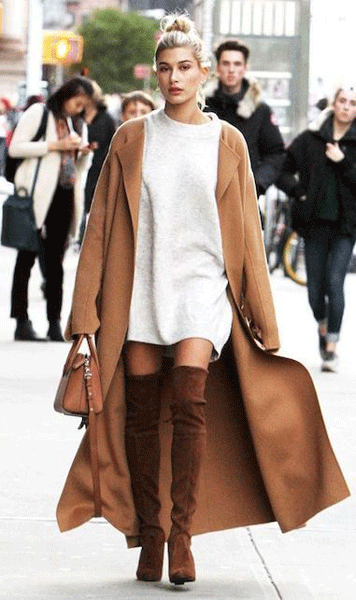 Stivali alti con tacco marroni abbinati a maglione oversize